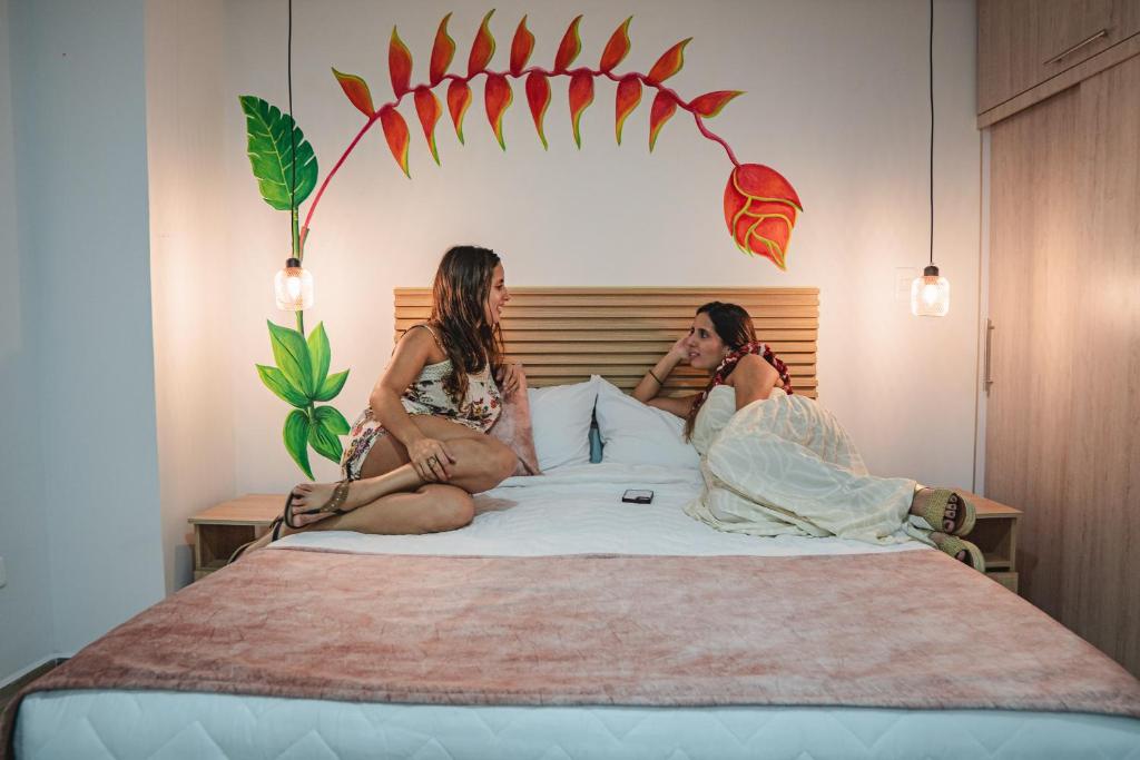 Un uomo e una donna seduti su un letto di HELICONIA Enjoy new comfortable studio apartment with terrace a Cali