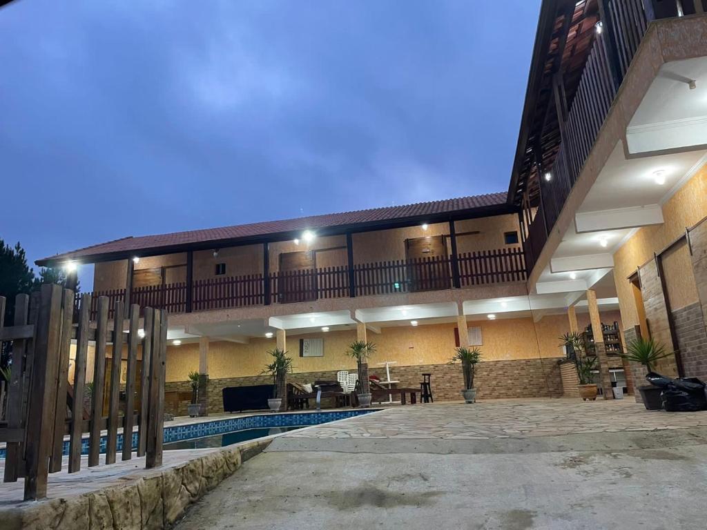 ein großes Gebäude mit einem Pool und einem Balkon in der Unterkunft PousadaRR in Iupeba