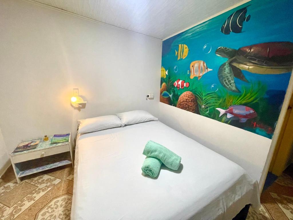 Zimmer mit einem Bett und einem Fischgemälde an der Wand in der Unterkunft Mr. Tenloy's Place in San Andrés