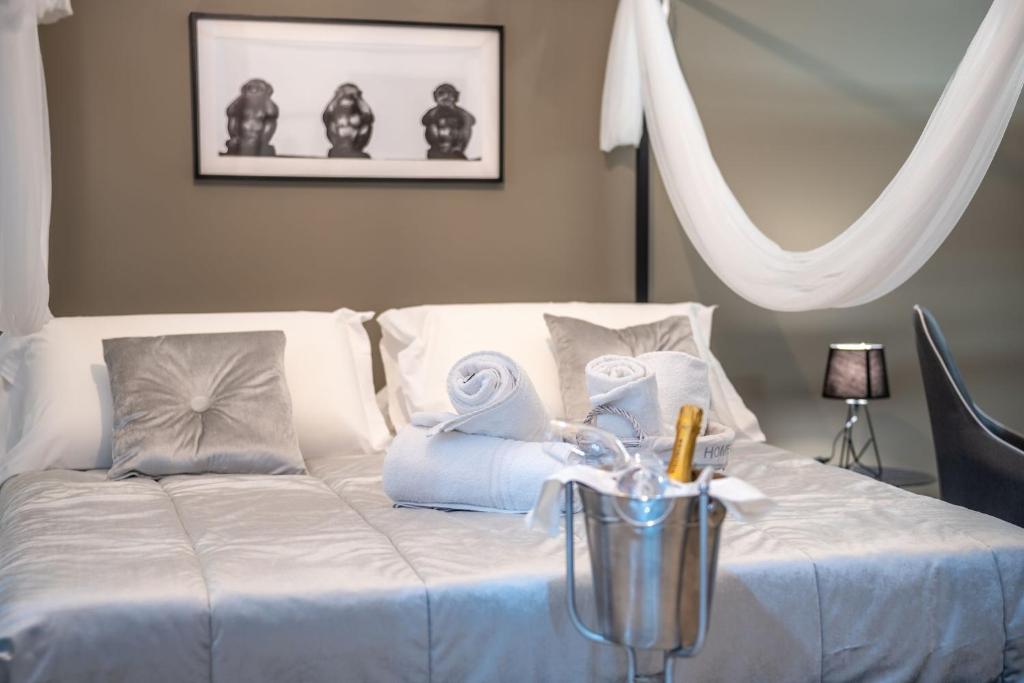 een wit bed met handdoeken en een vaas erop bij la porta di Alba in Palermo