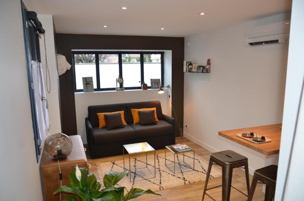 a living room with a couch and a table at Le Burlat - Studio - Lyon - Tassin in Tassin-la-Demi-Lune