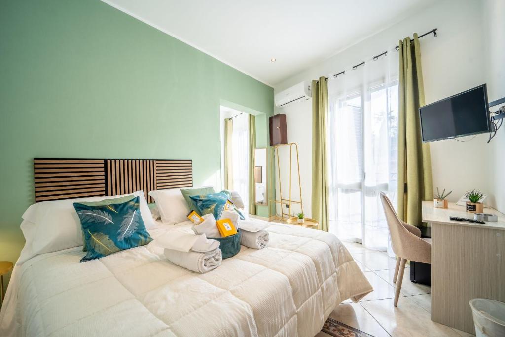 a bedroom with a bed with a desk and a television at la porta di Alba in Palermo