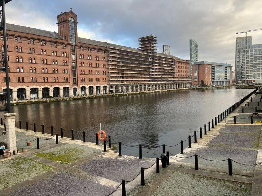 a river in front of a large brick building at Quayside City Escape - Liverpool in Liverpool