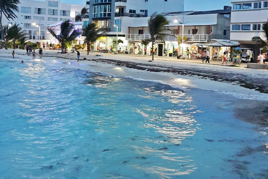 a beach with a body of water and buildings at Hotel Molino de Viento in San Andrés