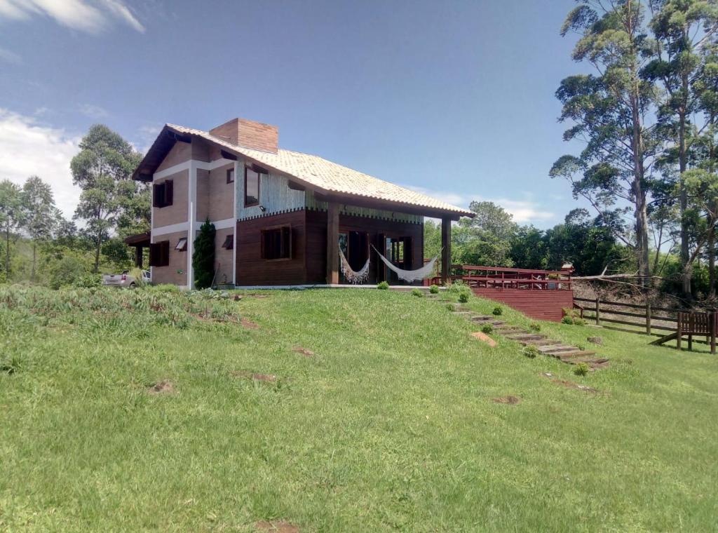 a small house in a field with a grass yard at Rancho 3 Guri in Osório