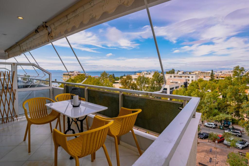 a balcony with a table and chairs and a view at Blue vibes by Glyfada beach in Athens