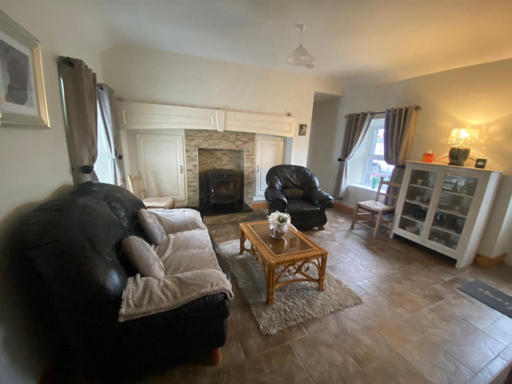 a living room with a couch and a coffee table at Cheerful 3 bedroom country farm house in Ennis