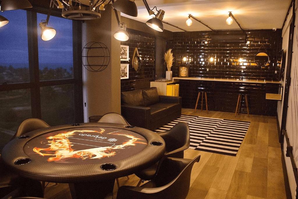 a room with a table and chairs and a bar at Park Del Prado #602 - Intermares por Carpediem in João Pessoa