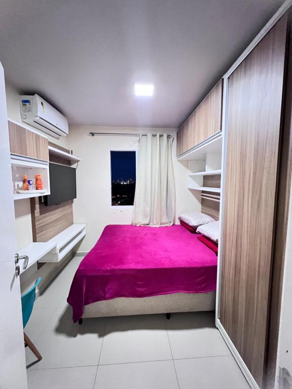 1 dormitorio con cama rosa y ventana en Apartamento vista ao mar en São Luís
