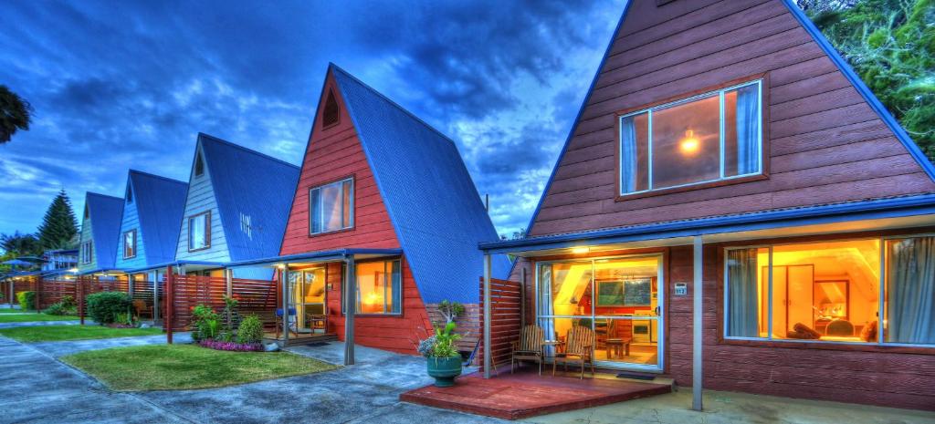 a row of houses with blue roofs at A-Frame Chalets @ Mokutu in Burnt Pine