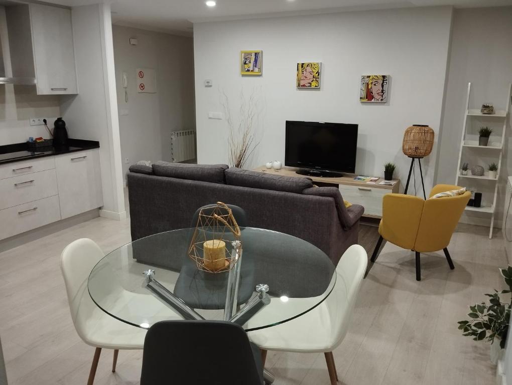 a living room with a couch and a glass table at Alojamiento Buenos Aires in Ourense