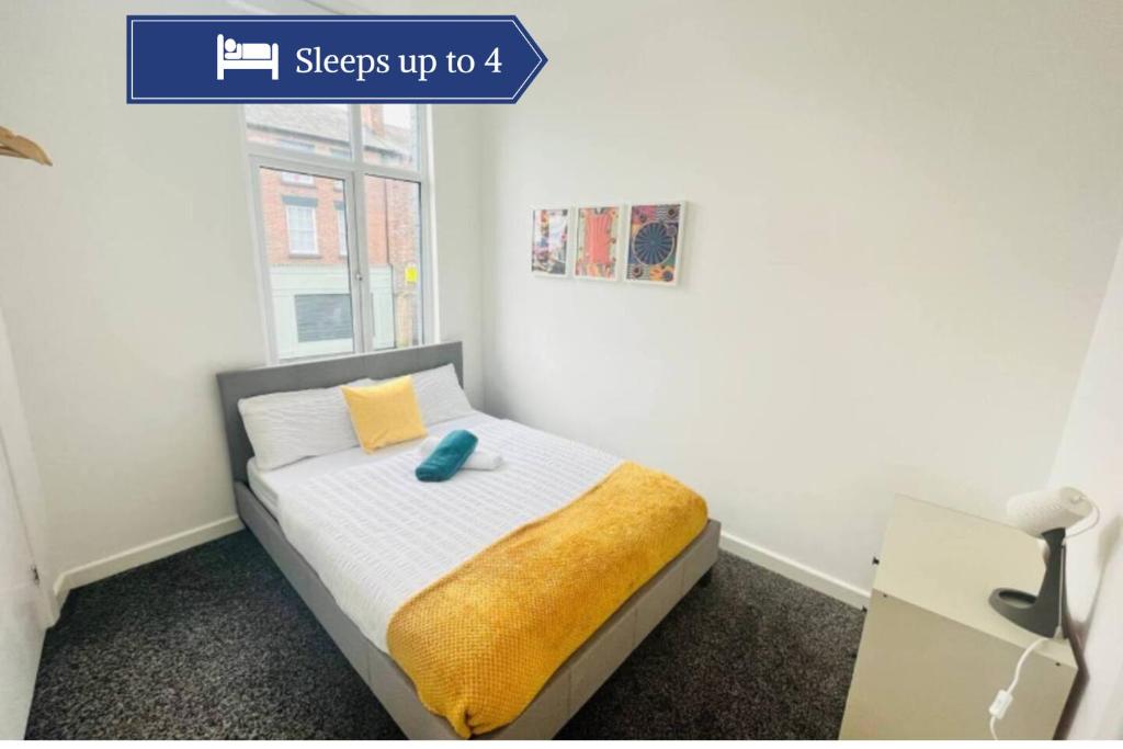 a bedroom with a bed with a yellow pillow and a window at Comfy Stylish 1BD Apt near Transport Links in Liverpool