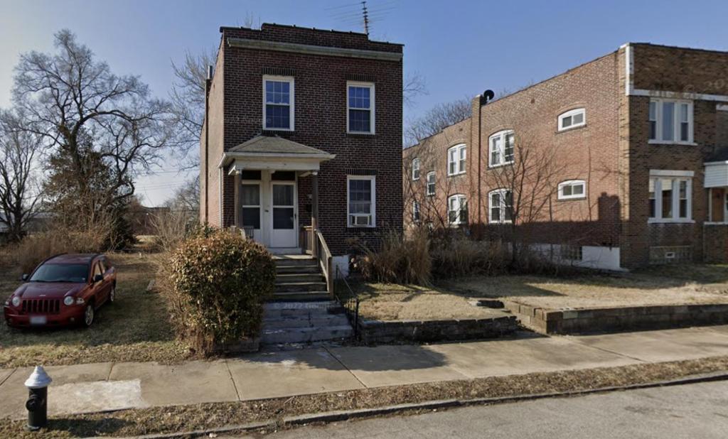 a red car parked in front of a brick house at Keur Koura in The Ville in Saint Louis