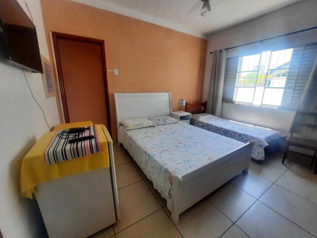 a bedroom with two beds and a window at Hotel Pousada das Rosas in São Lourenço