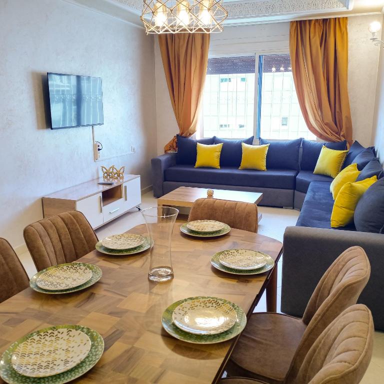 a living room with a table and a blue couch at Beautiful Apartment in centre ville M2 in Tangier