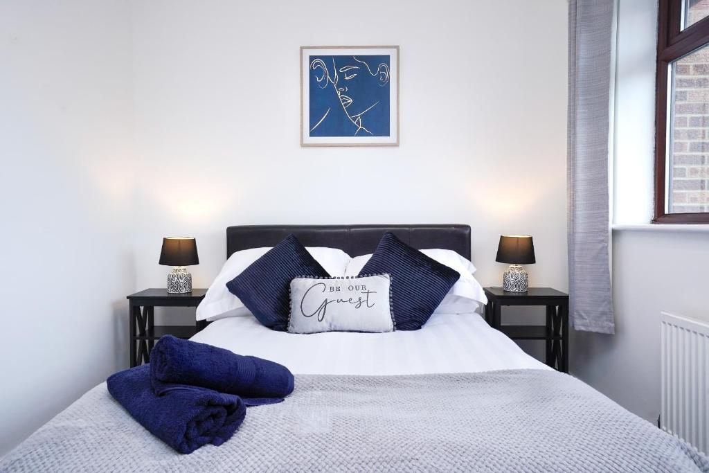 1 dormitorio con 1 cama con almohadas azules en Entire House in Cambridge, en Cambridge