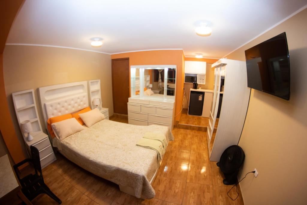 Dormitorio pequeño con cama y TV en Sunset en Chancay