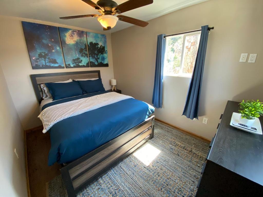 a bedroom with a blue bed with a ceiling fan at #2 - The Eagle's Perch in Pauma Valley