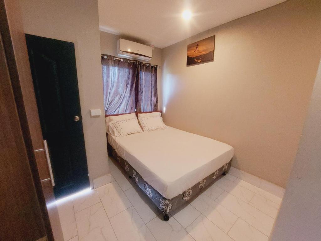uma pequena cama num pequeno quarto com uma janela em Double bed em Nadi