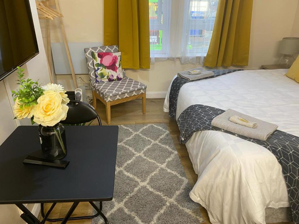 a bedroom with a bed and a table with a vase of flowers at AlphaStudio-Leeds-Walk 2-City-Centre-FreePark-Wifi in Leeds