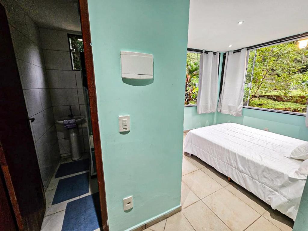 Habitación pequeña con cama y ventana en Sítio do Sossego, en Cachoeiras de Macacu