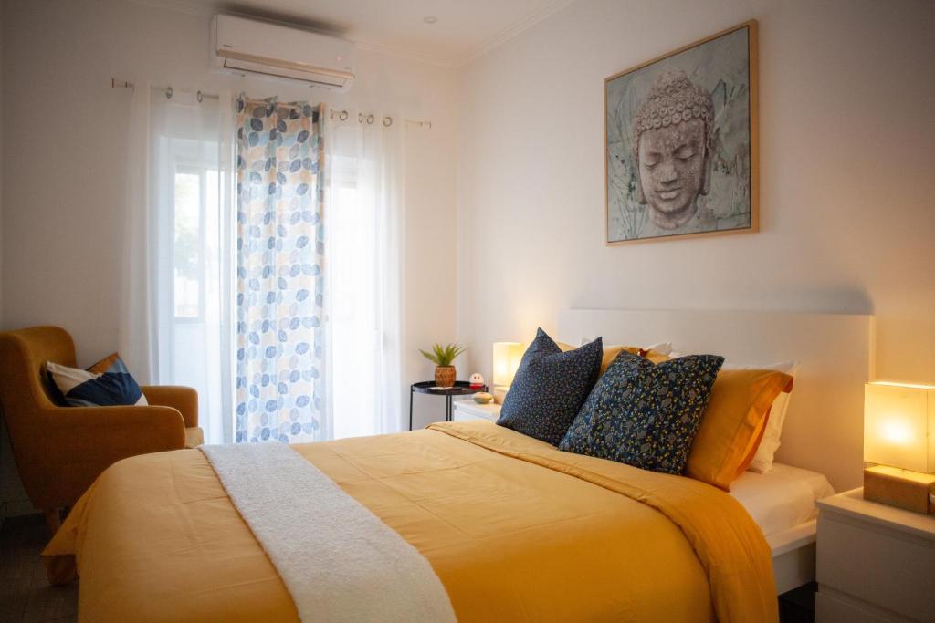 - une chambre avec un lit doté de draps jaunes et une fenêtre dans l'établissement Just4u Apartment, à Almada