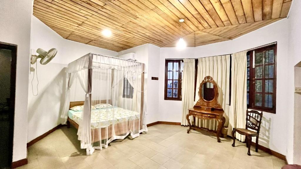 een slaapkamer met een bed en een stoel in een kamer bij Pearl House in Kandy