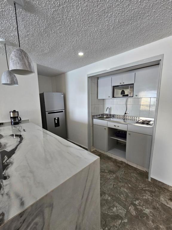 a kitchen with a sink and a refrigerator at Apartamento Torres gemelas in Acapulco