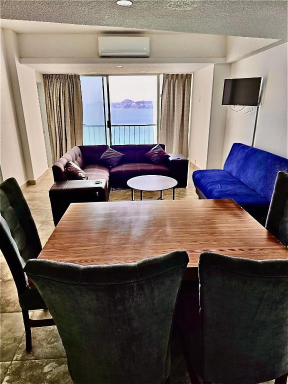 a living room with a table and a blue couch at Apartamento Torres gemelas in Acapulco