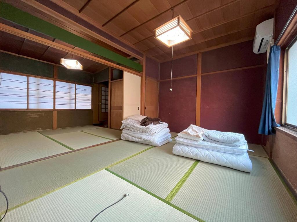 an empty room with two mattresses on the floor at 福井駅から徒歩2分の1棟貸切民泊 最低限 in Fukui