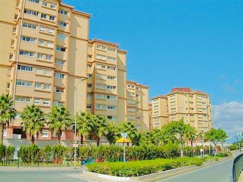 un gran edificio con palmeras frente a una calle en Lovely & Cosy Deluxe Home in Gibraltar en Gibraltar