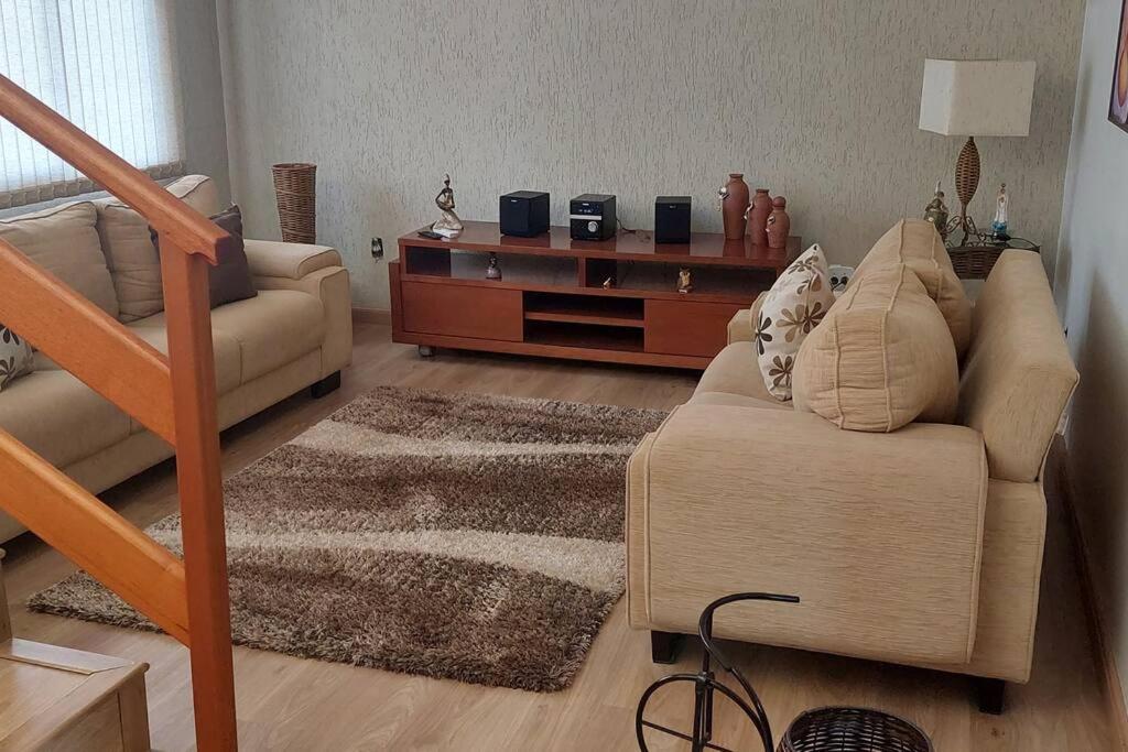 a living room with a couch and a table at Casa/Sobrado em Araraquara-SP in Araraquara