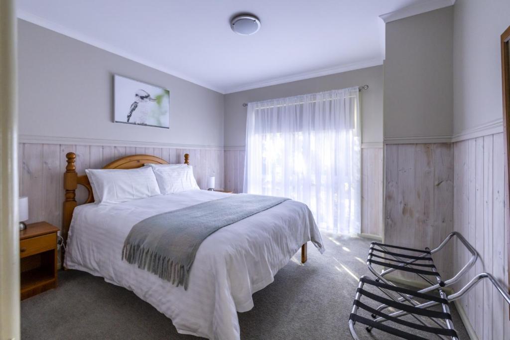 a bedroom with a large bed and a window at The Crays Accommodation in Strahan