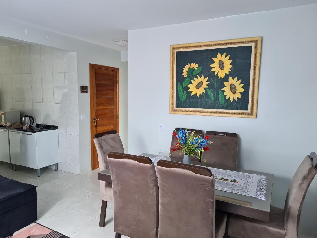 a dining room with a table with chairs and a painting at Ap 03 edificio Sao Paulo I in Ponta Grossa
