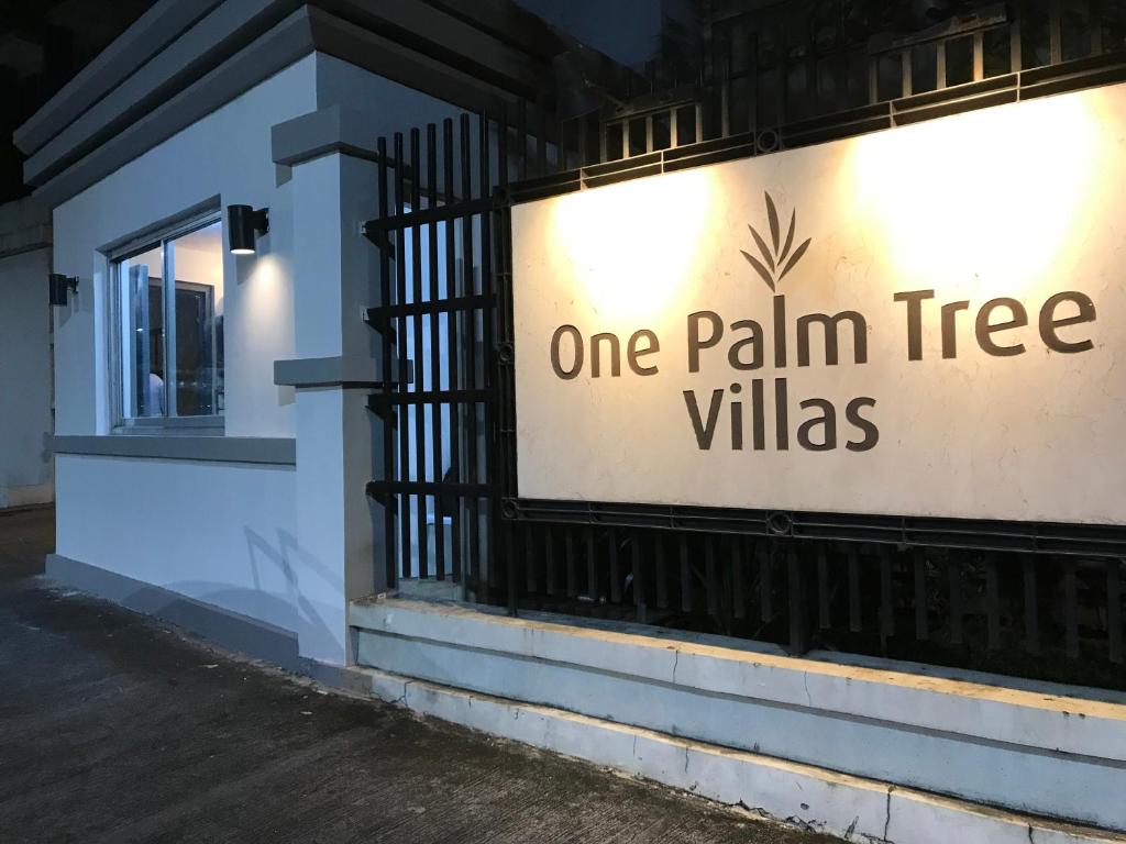 馬尼拉的住宿－Condo Palm Tree 1 Across NAIA T3，一座棕榈树别墅的标志,在建筑物的一侧