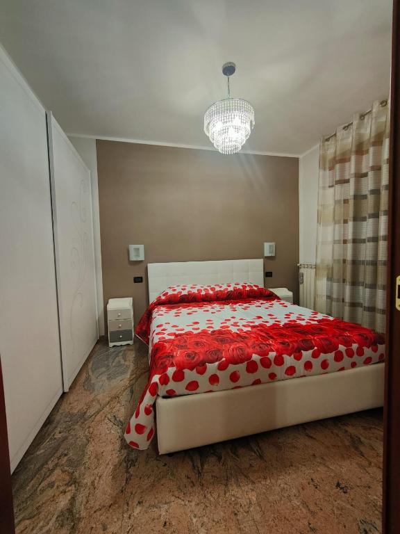 um quarto com uma cama grande e um edredão vermelho em La Chicca em Cosenza