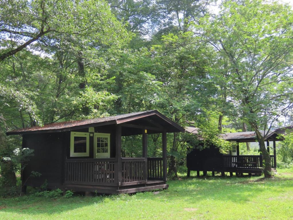 uma pequena cabana com um alpendre na relva em -be- Kita Karuizawa Camp Field - Vacation STAY 42270v em Kita-karuizawa