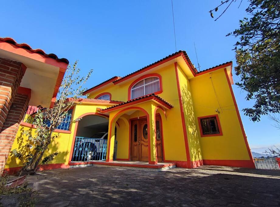 una casa amarilla y roja con entrada en Casa completa a 10 min de Teziutlan., 
