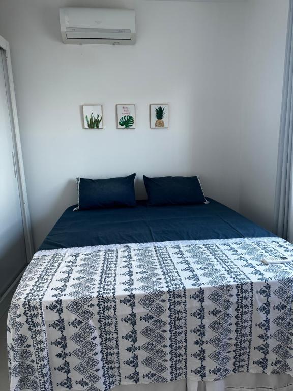 a bedroom with a bed with a blue and white quilt at Casa pé na areia em Gamboa do Morro de São Paulo in Cayru