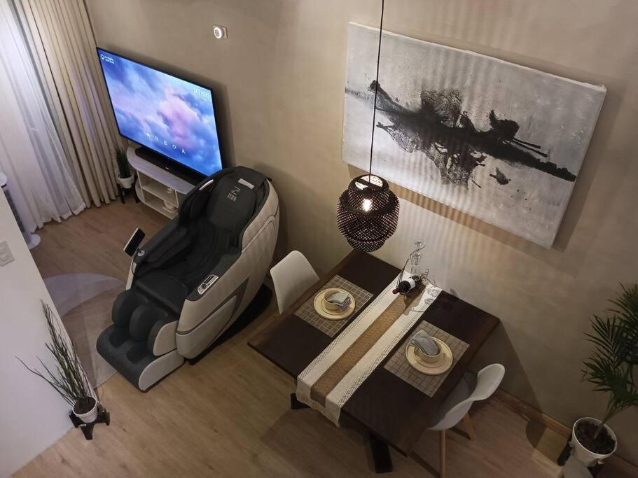 un salon avec une télévision, une table et une chaise dans l'établissement WHT Pod, 