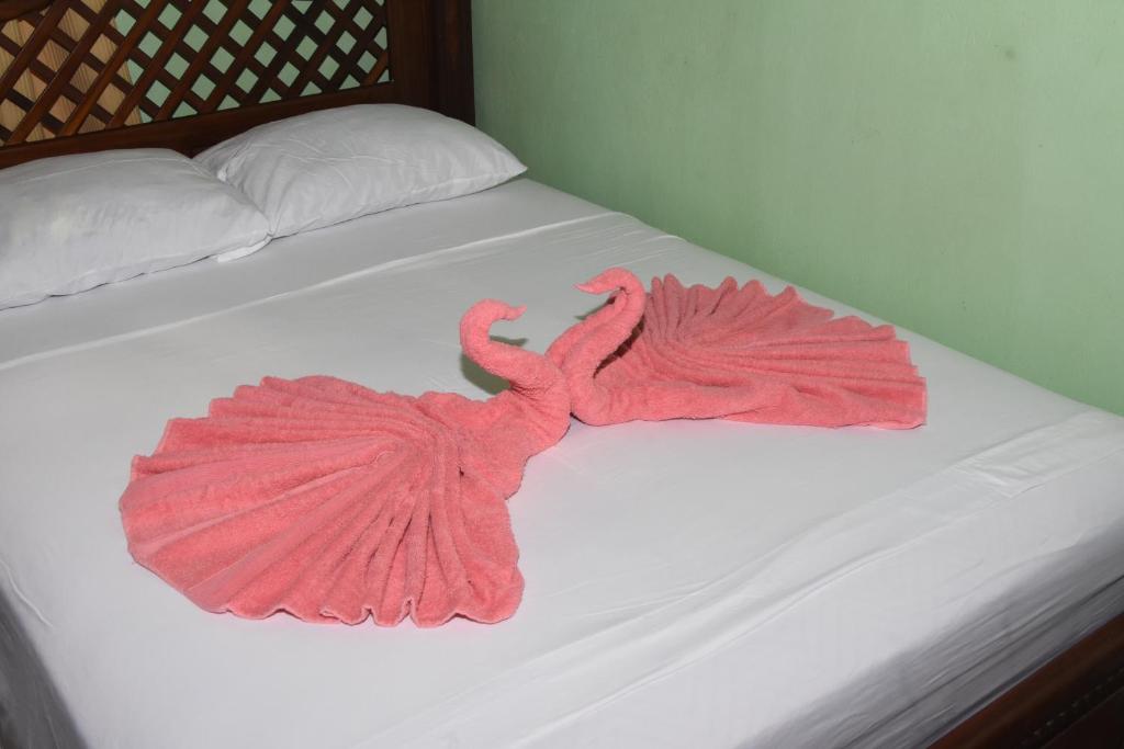 two pink flamingos are laying on a bed at Osa House - Drake Bay in Drake