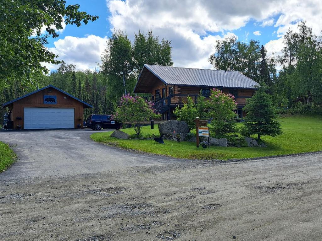 a house with a car parked in front of a driveway at Southern Bluff Bed & Breakfast in Soldotna