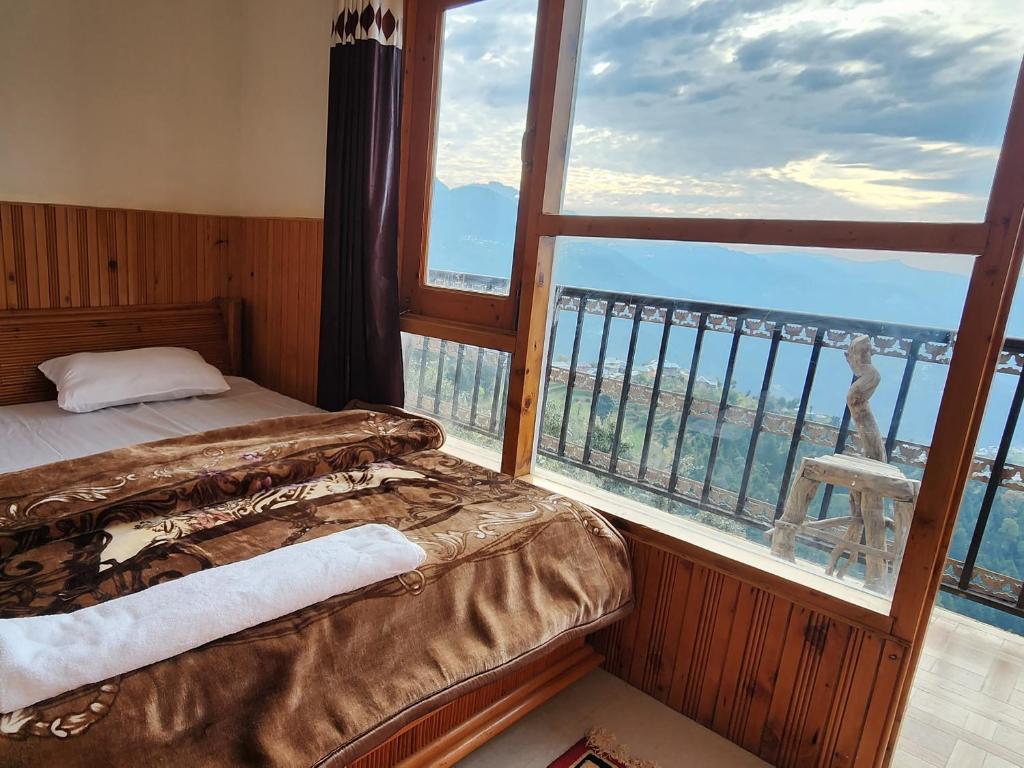 1 dormitorio con cama y ventana grande en HILL MOUNT VIEW DALHOUSIE, en Chamba