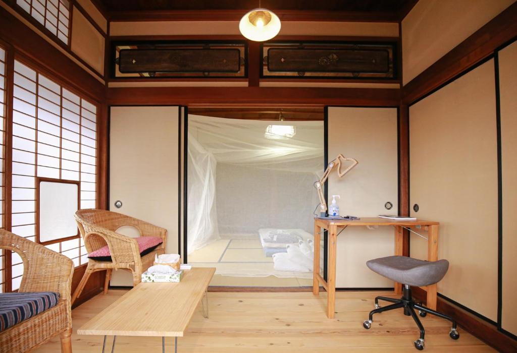 熊野市にあるAbuden in Kumano for women and families 女性と家族専用の宿のベッド、デスク、椅子が備わる客室です。