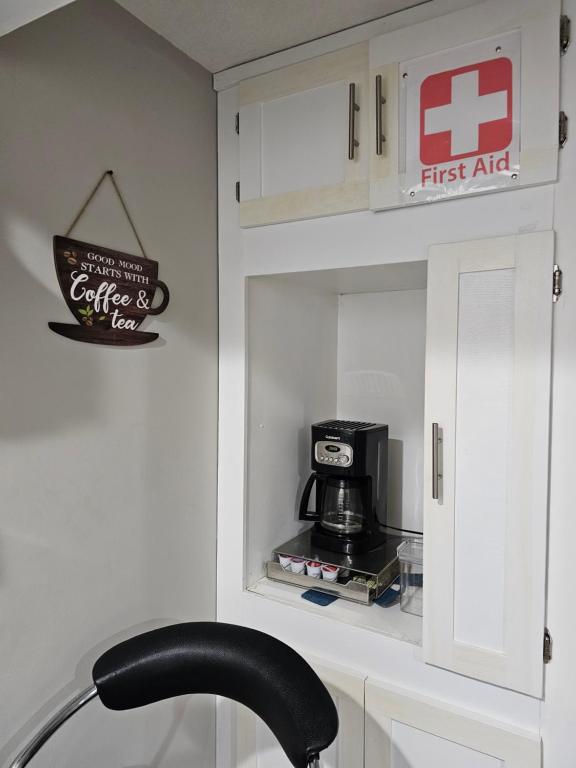 una cucina con credenza e macchinetta del caffè di Amazing cozy fully private studio a London