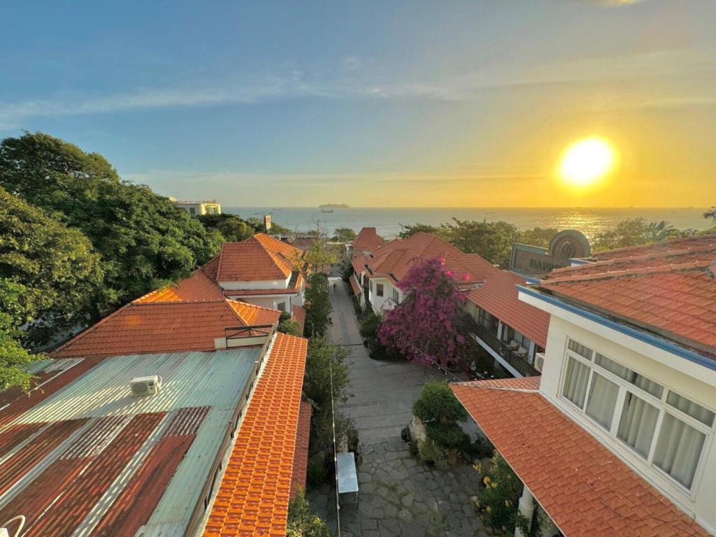 una vista aérea de los tejados de las casas con la puesta de sol en VND Vũng Tàu Hotel & Villa, en Vung Tau