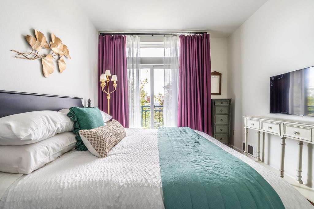 Hotel Seattle Among The Trees: in Belltown w/Parking!, a bedroom with a large bed with purple curtains at Seattle Among The Trees: in Belltown w/Parking! in Seattle