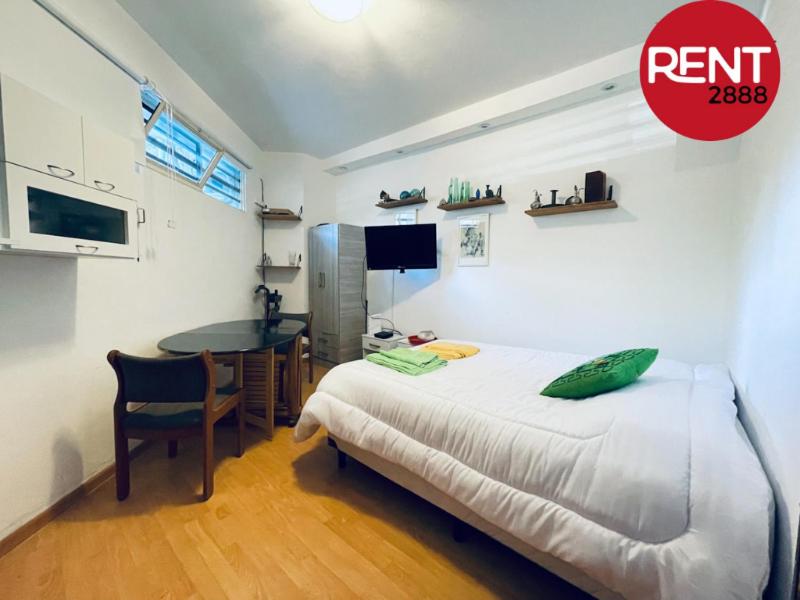 1 dormitorio con cama, escritorio y mesa en Rent Ugarte en Buenos Aires