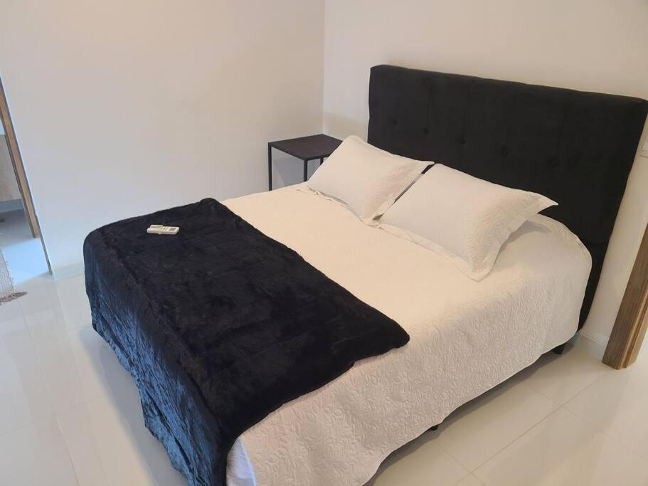 Una cama con una manta negra encima. en Bella casa de playa Mar Adentro, en Santa Cruz de la Sierra