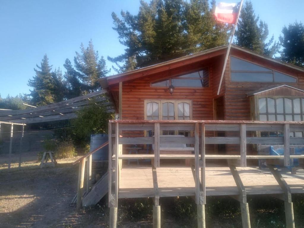 eine Blockhütte mit einer Veranda und einem Haus in der Unterkunft Cabañas Laguna Seca 